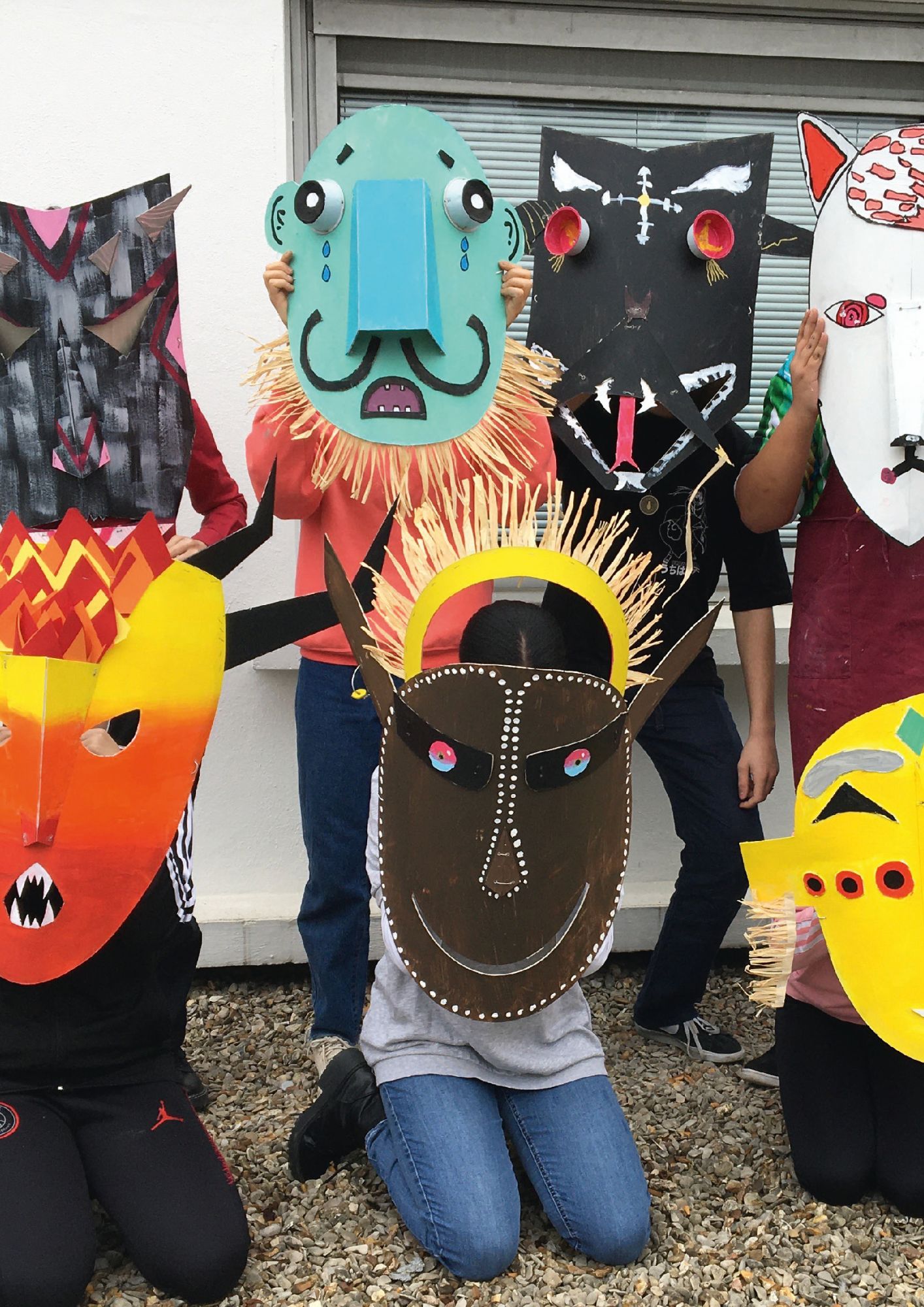 Enfants portant les masques réalisés pendant le cours d'expression artistique